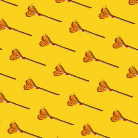 Repeating print of yellow candy hearts, valentine's day concept.の写真素材