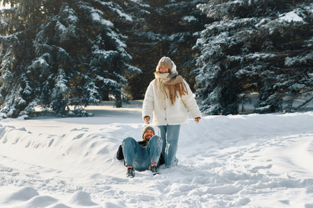 A young couple is playing in the winter forest with each other. Fabulous snowy winter.の写真素材