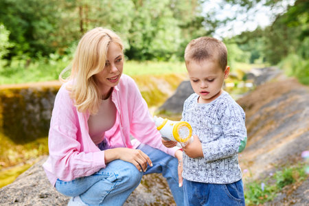 Childhood concept. Mom and her son went out to the park to blow bubbles.の写真素材