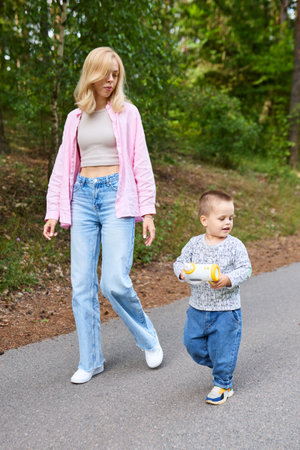 The babysitter went for a walk with the boy.の写真素材