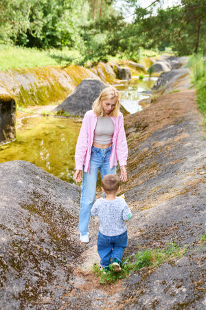 Childhood concept. Mom went out with her son walking a steep path in the forest.の写真素材