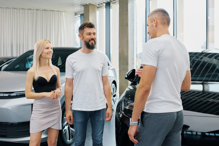 European man and women negotiate the purchase of a new car at a car dealership.