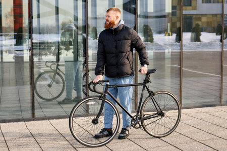 A red-haired man with a beard took his bike for a ride.の写真素材