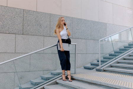 Young business woman dressed in white t-shirt and black pants goes to interview.の写真素材