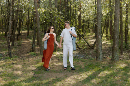 A young couple walks through the park. Summer picnicの写真素材