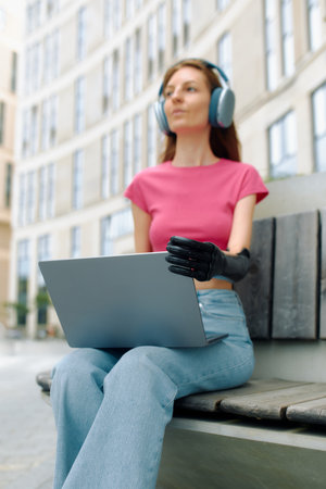 Bionic prosthesis enables woman to work on her laptop in outdoor space.の写真素材