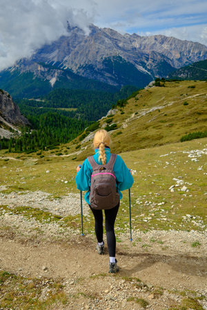 A person walks along a mountain path, enjoying the stunning scenery of nature and sunshine.の写真素材