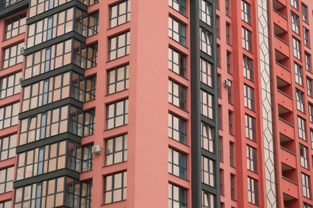 A pink brick apartment building with multiple windows and balconies.の写真素材