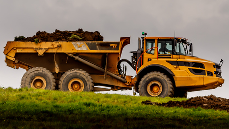 Heavy earth mover used to reshape the landscape of a landfill siteの写真素材