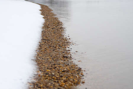 Flat water with snowy bank