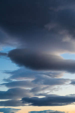 Dark cloud formation vertical orientation blue orange yellowの写真素材