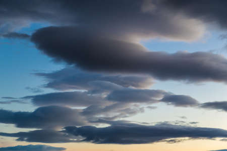 Dark cloud formation horizontal orientation blue orange yellowの写真素材