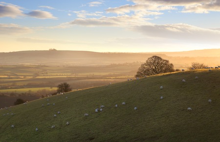 The sun rising a Cotswold landscape near Ilmington, Warwickshire, England 