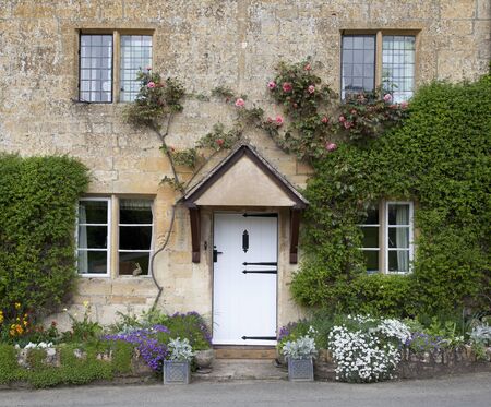 Pretty Cotswold cottage with spring-flowering border, Stanton, Gloucestershire, England の写真素材
