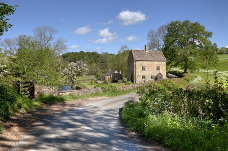Pretty cottage on the banks of the River Dikler, Gloucestershire, England 