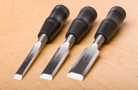 three chisel on wood background