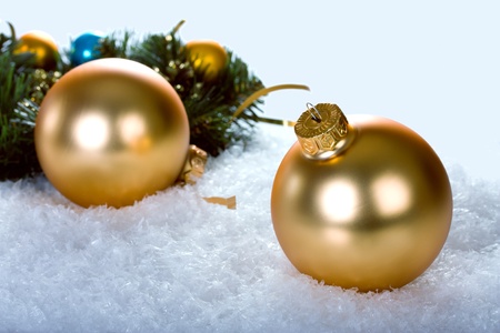 golden christmas balls with branch christmas tree on blue snowの写真素材