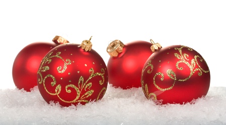 red christmas balls with pattern on snow on white backgroundの写真素材