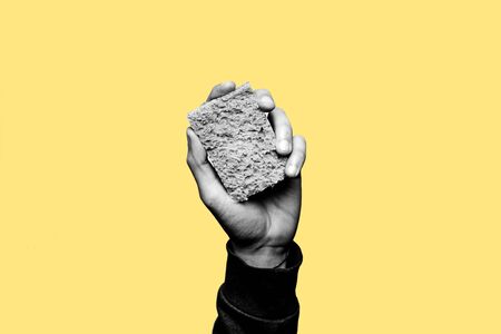 Concept of staying clean from alcohol and drugs. Stay sober. Hand holding a cleaning sponge in black and white. Yellow backgroundの写真素材