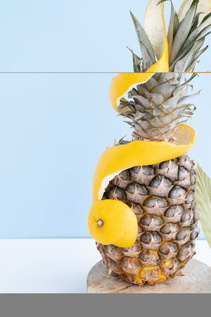 Pineapple in orange peel on a monochromatic background. High quality photo