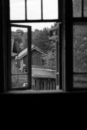 View from the window of an old abandoned wooden house. Black and white photo.の写真素材