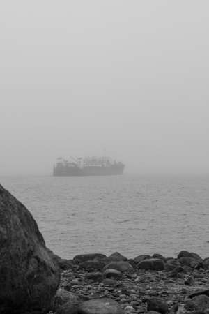 Cargo ship in the sea. Black and white photo of cargo ship in the fog.の写真素材