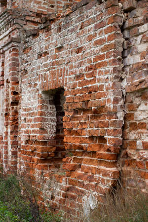 Old red brick wall with a hole in the middle. The ruins of an ancient fortress.の写真素材
