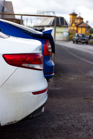 Rear view of white car parked on the side of the roadの写真素材