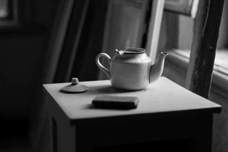 Vintage teapot on the table. Black and white photo.の写真素材