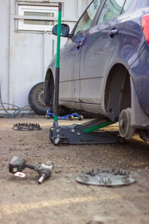 Car mechanic changing tire in auto repair service. Car service concept.の写真素材