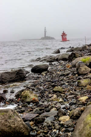 Lighthouse in the fog on the shore of the Baltic Sea.の写真素材