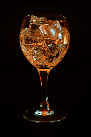 Cocktail in a glass with ice cubes on a black backgroundの写真素材