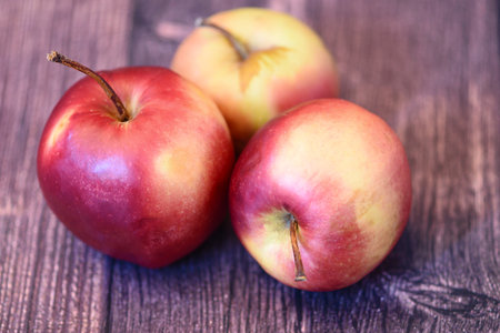 Red apples on a wooden background. selective focus. Shallow depth of field. Toned.の写真素材