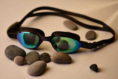 Swimming goggles and stones on a light background. sport equipment.の写真素材