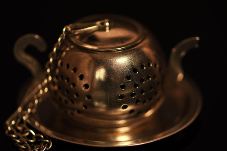 Antique brass teapot on a black background. selective focus.の写真素材