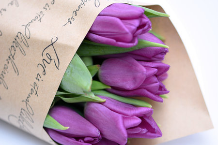 Bouquet of purple tulips in a paper bag with a handwritten inscriptionの写真素材