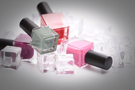 Nail polish bottles and ice cubes isolated on white backgroundの写真素材