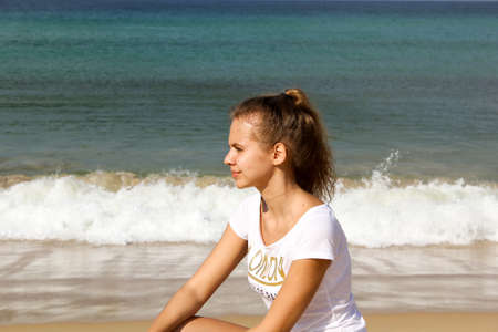 Young thoughtful girl on the beach , looking into the distanceの写真素材