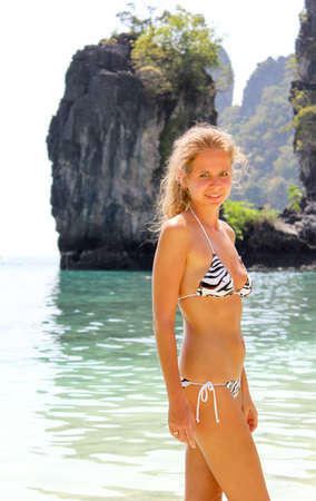 Portrait of a young girl on the beach against the sea and rocksの写真素材
