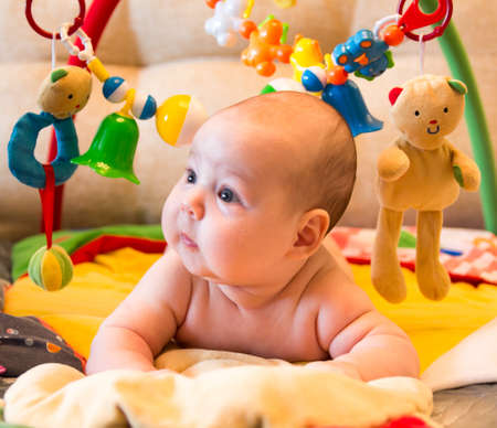 Cute baby girl lying on the background of  toysの写真素材