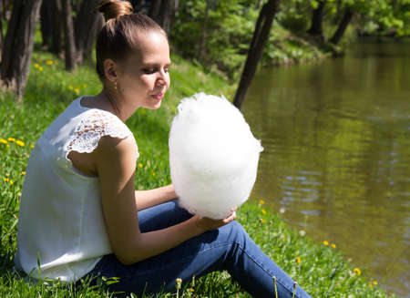 Beautiful girl holding a cotton candyの写真素材