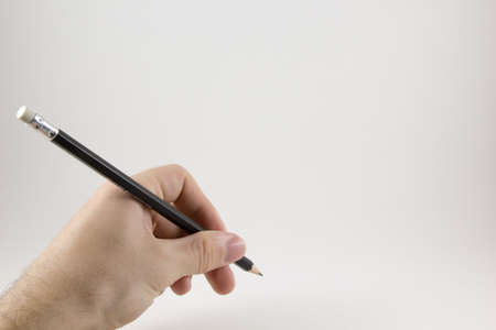 Hand with a pencil on a white backgroundの写真素材