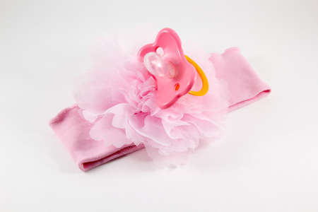 Pink bow and a nipple on a white background