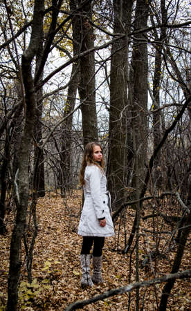 Portrait of a beautiful girl on a background of dry branchesの写真素材