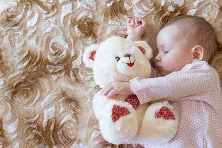 Baby sleeping with teddy bearの写真素材