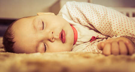 Cute newborn baby sleeping on the bedの写真素材