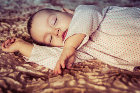 Cute newborn baby sleeping on the bedの写真素材