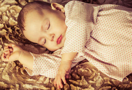 Cute newborn baby sleeping on the bedの写真素材