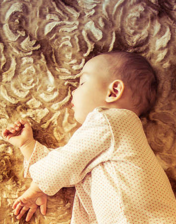 Cute newborn baby sleeping on the bedの写真素材