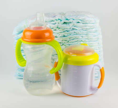 Baby diapers and bottles on a white backgroundの写真素材